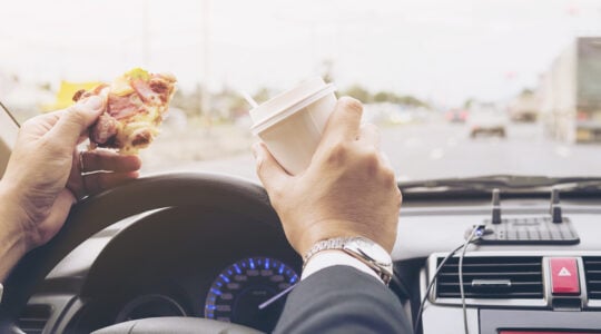 man-eating-pizza-coffee-while-driving-car-dangerously-Easy-Resize.com
