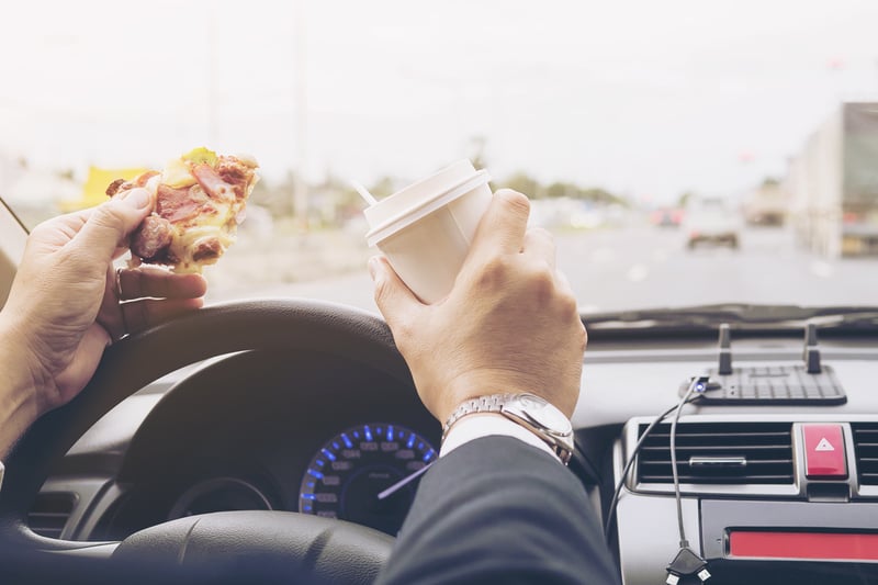 man-eating-pizza-coffee-while-driving-car-dangerously-Easy-Resize.com