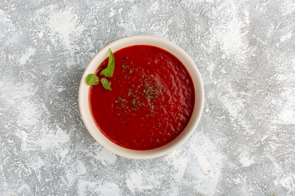 top-view-delicious-tomato-soup-with-seasonings-grey-table-soup-meal-dinner-vegetable