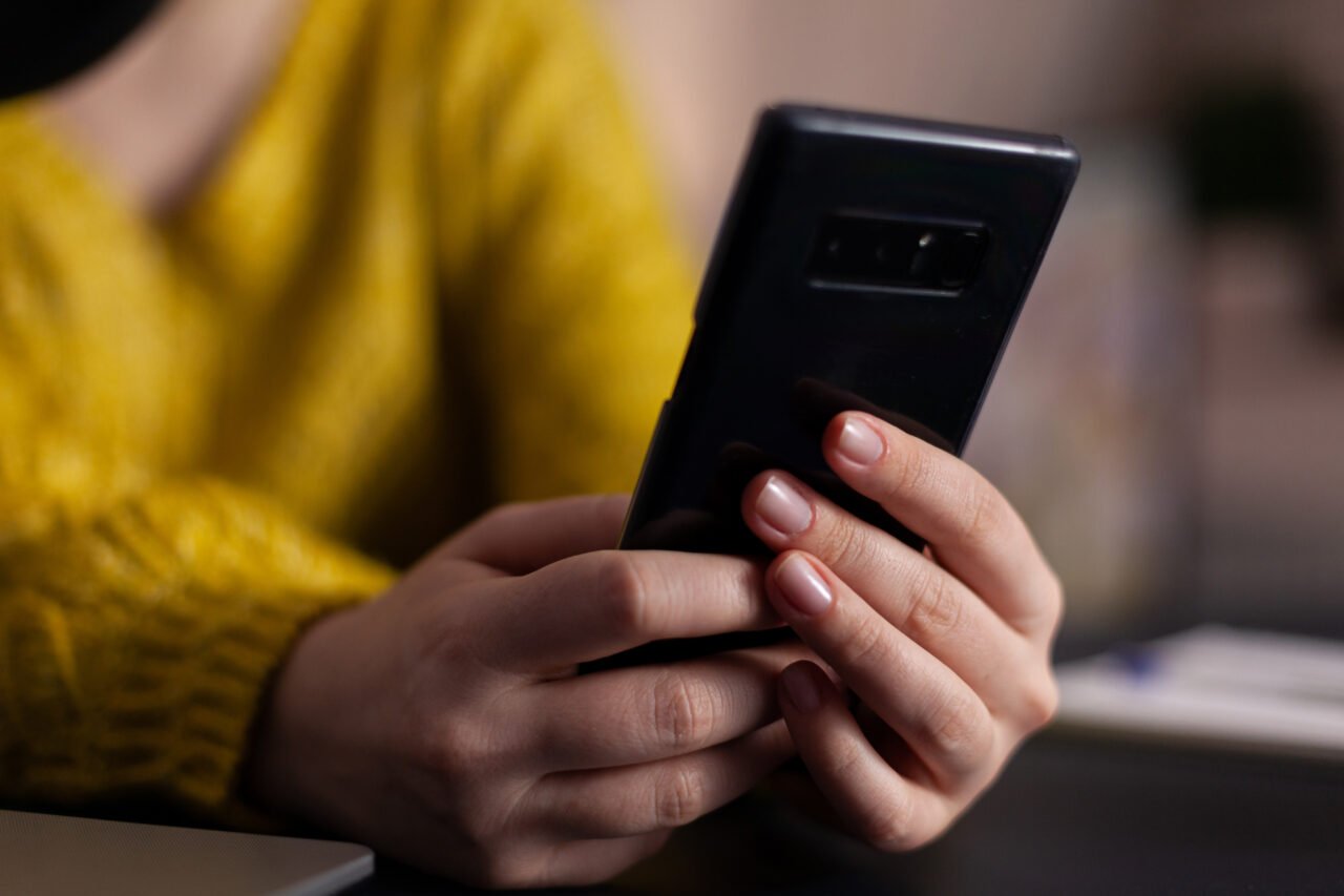 Closeup of social media vlogger with headset holding smartphone