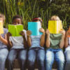 Children reading books at park