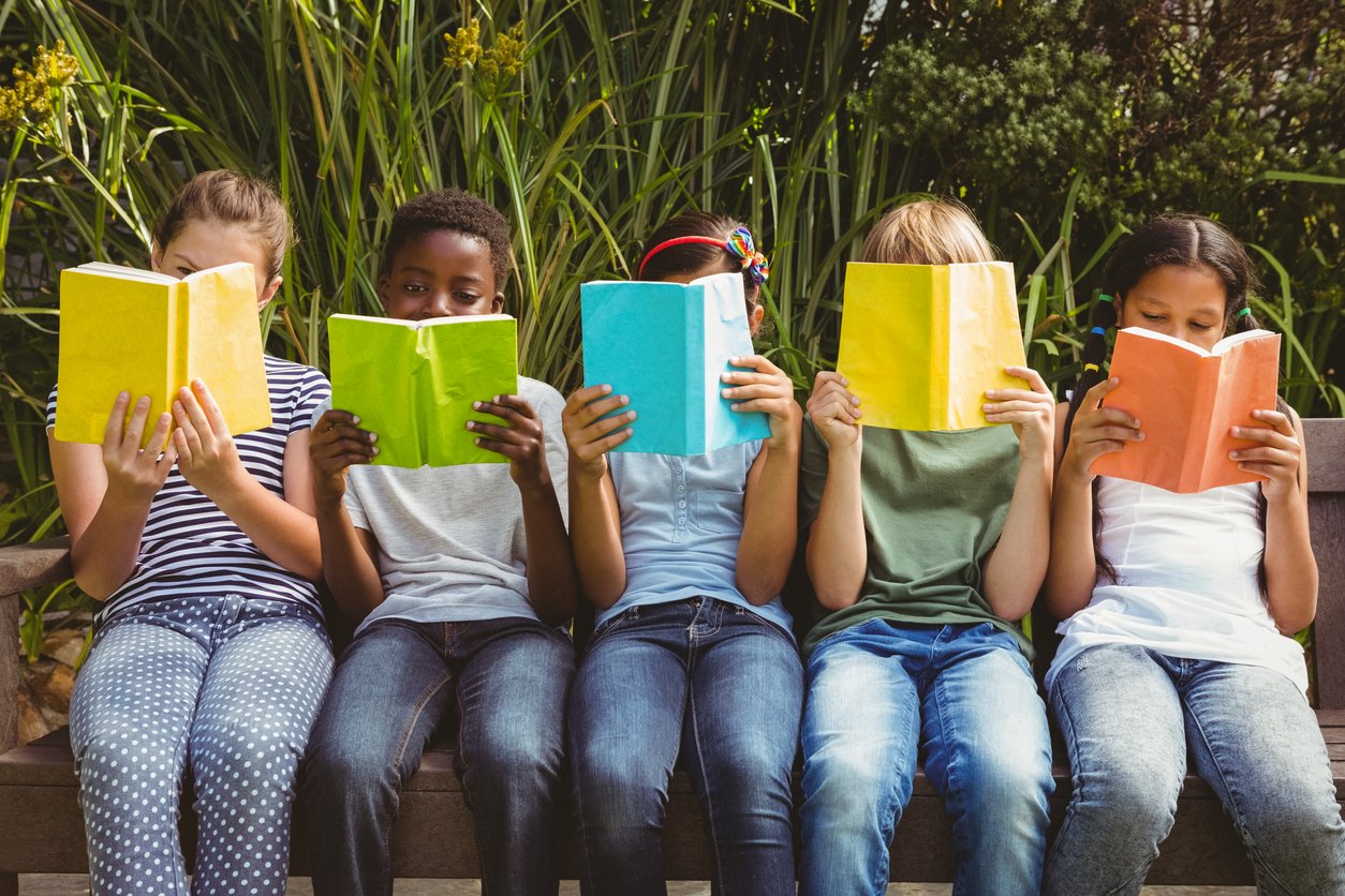 Children reading books at park