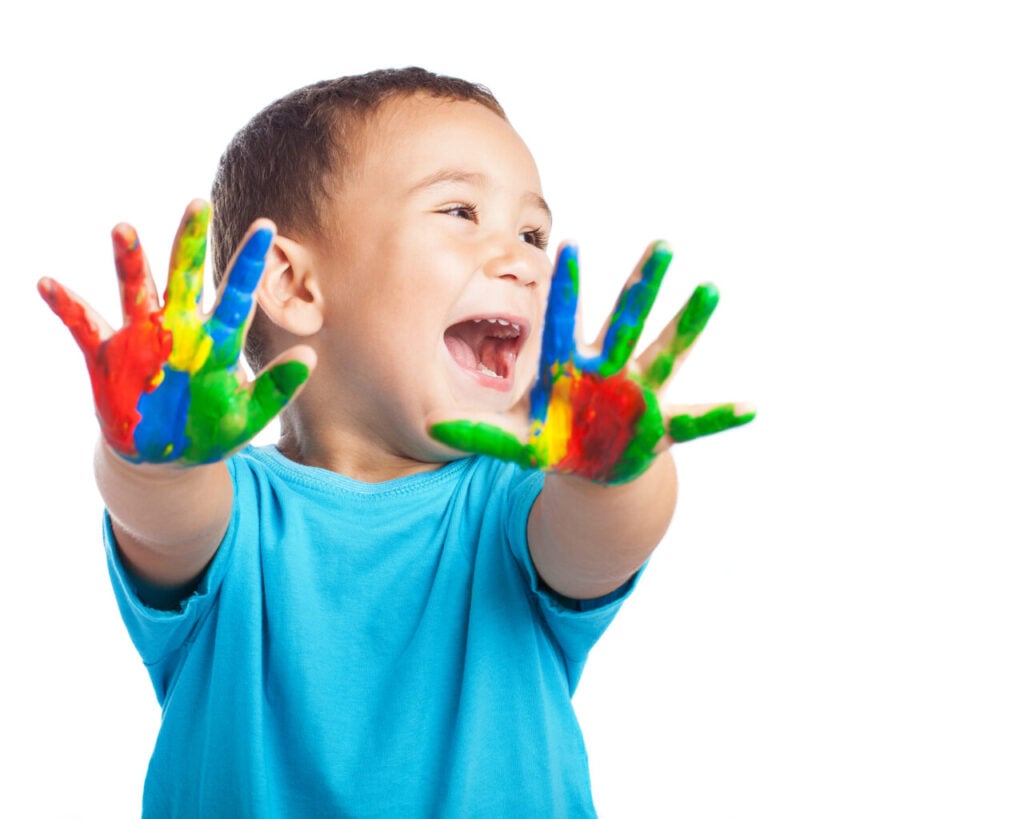 cheerful child with painted hands on white background