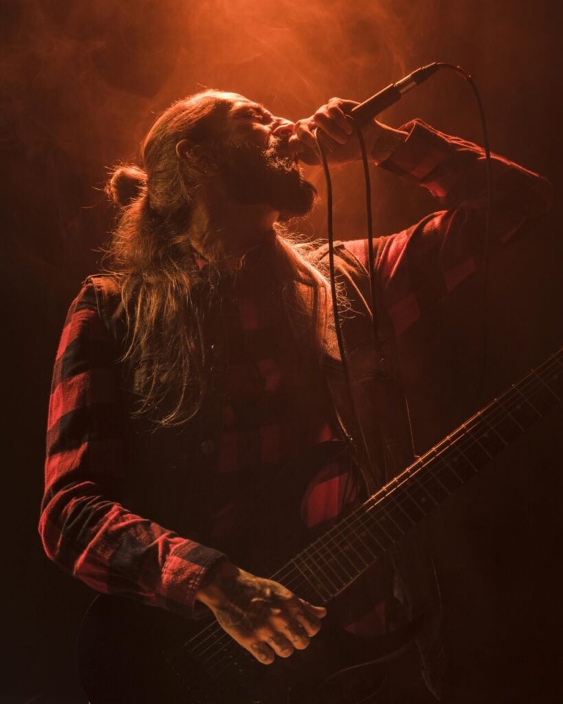 long-hair-guitar-guy-singing-low-view (1)