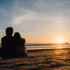 Young Asian couple watching sunset near beach, sweet couple happ